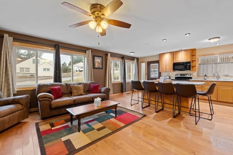 Custer Central Cottage features a bright and inviting open-concept living space with comfortable seating, beautiful hardwood floors, a fully equipped kitchen, and plenty of natural light.