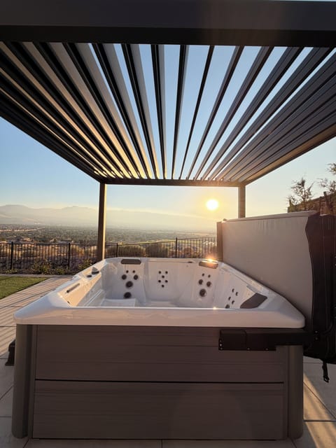 Sunset-view hot tub under a modern pergola with stunning city vistas