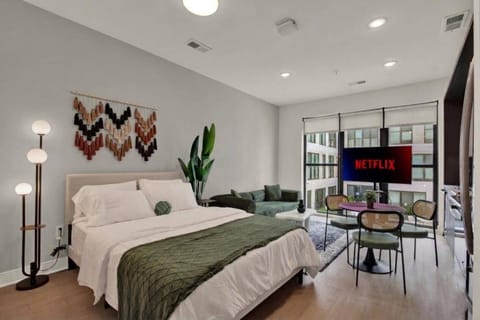 Bright modern studio with city views, dining nook, and cozy lounge area