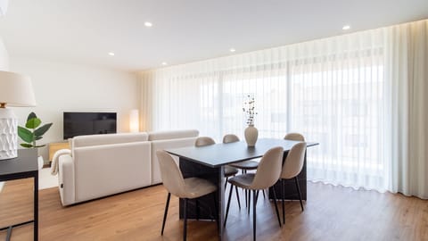 Gather around the stylish dining table for memorable meals, then unwind on the comfortable sofa in this elegantly designed open-plan area, bathed in natural light.