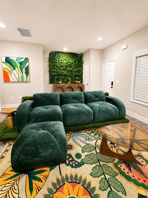 Lush, designer living room with green sectional and bold tropical style