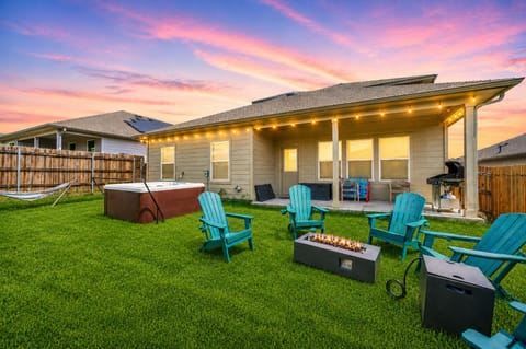 Backyard oasis with hot tub, fire pit, hammock and string-lit patio