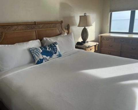 Bright tropical-style bedroom with plush king bed and natural light