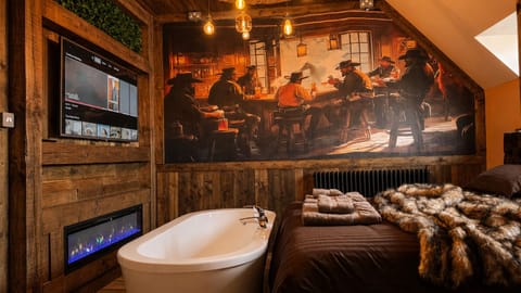 Bedroom 2, the "Hat Room," features a super king or two singles plus an extra single bed for flexibility. It includes a bath and an additional ensuite toilet.