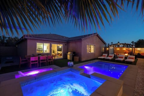 Private pool and spa glow with colorful evening lighting, creating a resort-style setting for relaxing.
