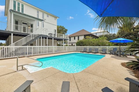 A private oasis awaits beyond your back door—gleaming turquoise water, lounge chairs shaded by palms, and a sun-drenched deck perfect for lazy afternoons.