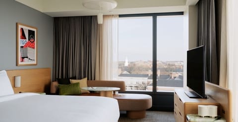 Wake refreshed in crisp linens beside expansive city views.