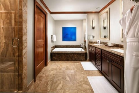 Spa-like bathroom with soaking tub, glass shower, and dual vanities