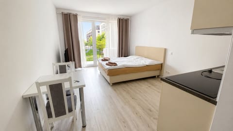 Bright modern studio with kitchenette and sunny garden-facing doors
