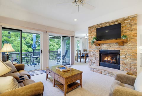 Gather around the stone fireplace after a day on the mountain, with a large-screen TV above and the deck just steps away.