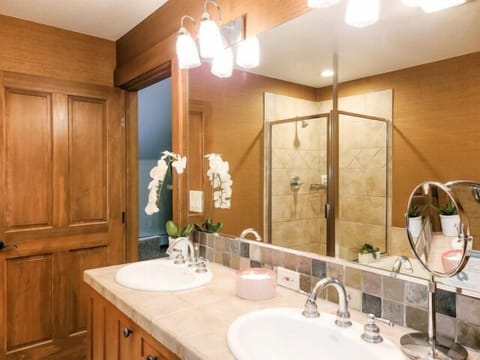 Warm double-vanity bath with glass shower and spa-like charm