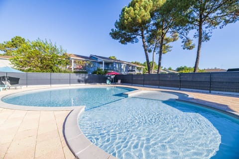 Ease into the curved outdoor pool, framed by pine trees and a sunny terrace.