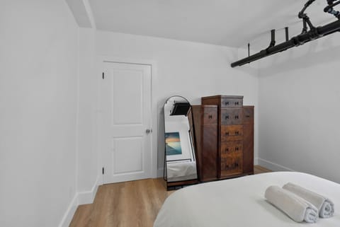 Minimalist bedroom with dresser, full-length mirror, and modern industrial style