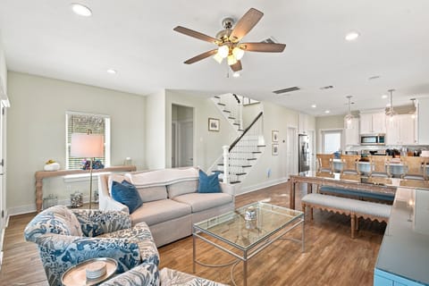 Bright open living space with modern kitchen, island seating, and stylish decor