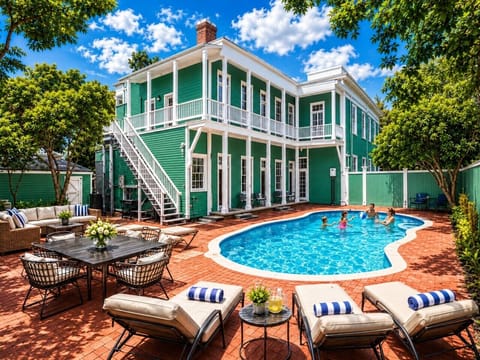 Pool area and back yard with sun loungers, outdoor dining area, and seating around fire pit.