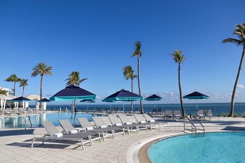 Stretch out poolside with palm trees framing the water and lounge chairs steps from the edge.