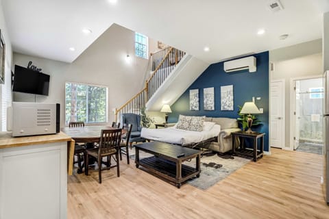 The open layout keeps everyone connected, with the kitchenette counter opening straight onto the dining and living areas. Wood chairs pull up around the table while the Smart TV keeps the seating area casual and inviting.