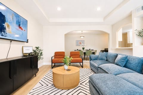 Bright open living room with plush seating, smart TV, and dining area