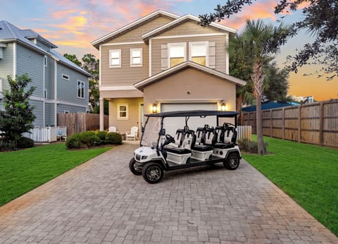 Golden-hour curb appeal with a six-seat golf cart ready for easy coastal adventures.