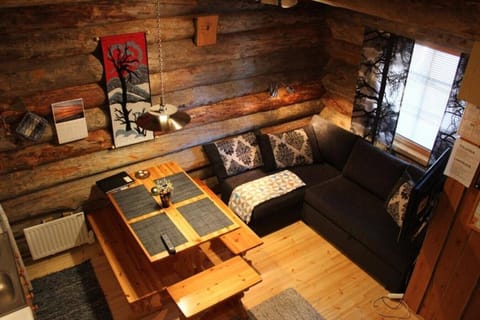 Cosy living room with a corner sofa and a low wooden table under the log walls.