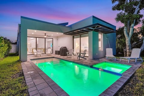 Heated pool and hot tub with 4 chairs, two loungers and a Weber grill.