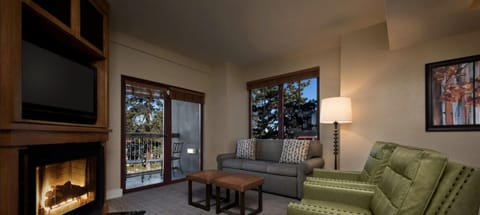 Cozy fireside lounge with balcony access and scenic treetop views