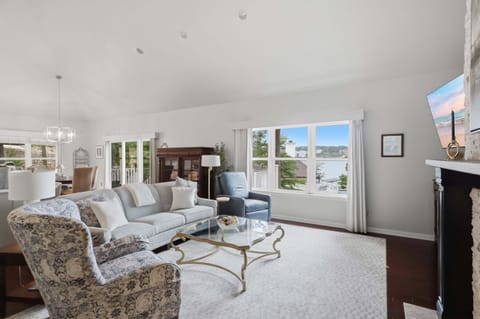 Spacious open-concept living area with comfortable seating, lake views, and easy access to the dining area and deck.