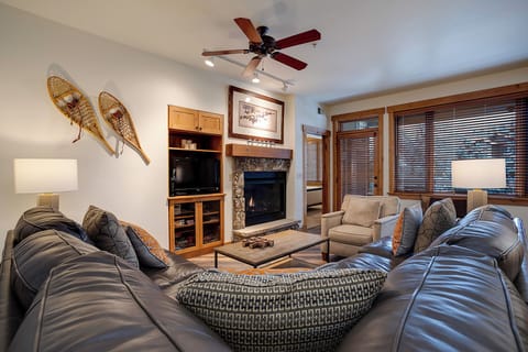Sink into plush seating and unwind by the cozy fireplace, where rustic mountain charm meets modern comfort in your living room retreat.