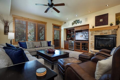 Sink into plush seating by your stone fireplace, where natural light and mountain charm create the perfect retreat for cozy evenings and relaxation.