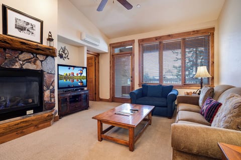 Sink into comfortable seating beside your warm stone fireplace, where rustic wood details and mountain light create the perfect setting for relaxation and connection.