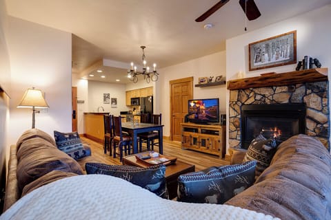 Sink into plush seating by your crackling stone fireplace, with rustic wood accents and a fully-equipped kitchen just steps away—your perfect mountain retreat awaits.