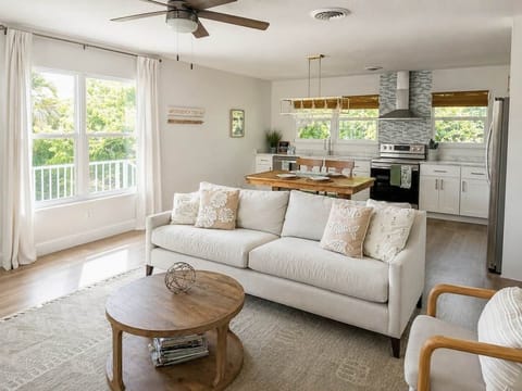 Bright and airy open floorplan living space. Windows overlook greenspace full of natural Florida Seagrape trees.