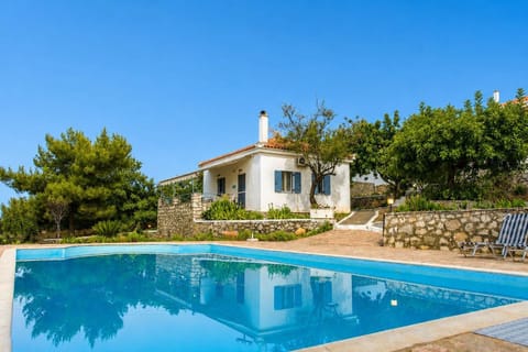 Large outdoor swimming pool surrounded by greenery and the peaceful hillside landscape.