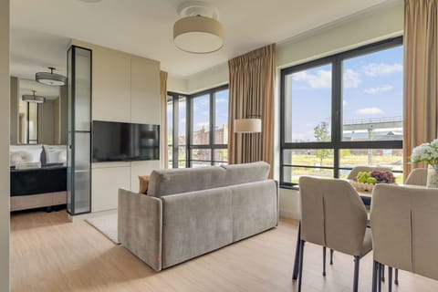 Salon jest komfortową przestrzenią do wypoczynku i wspólnego spędzania czasu. Znajduje się w nim wygodna sofa, która może pełnić funkcję dodatkowego miejsca do spania, oraz telewizor z dostępem do kanałów kablowych i funkcją Smart TV.