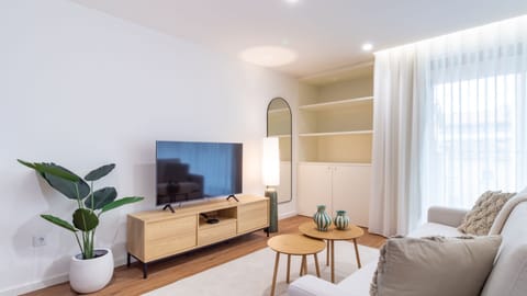 Step into a bright and airy living room, where natural light streams through sheer curtains, creating a welcoming atmosphere perfect for unwinding or enjoying quiet moments. #BrightLiving #SpaciousApt #ModernComfort #CityEscape #NaturalLight #ElegantDesig