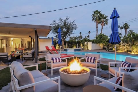 Unwind by your private pool with elegant fire pit seating, perfect for evening gatherings under swaying palms in this desert oasis retreat.