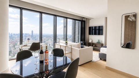 Área de comedor junto a la sala y grandes ventanales, perfecta para disfrutar alimentos mientras contemplas el skyline de Ciudad de México.