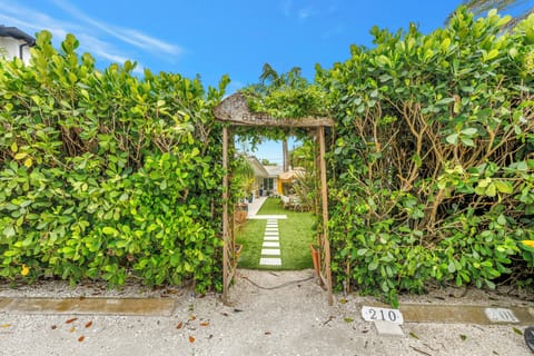 Private tropical garden entry with lush hedges and a charming pathway
