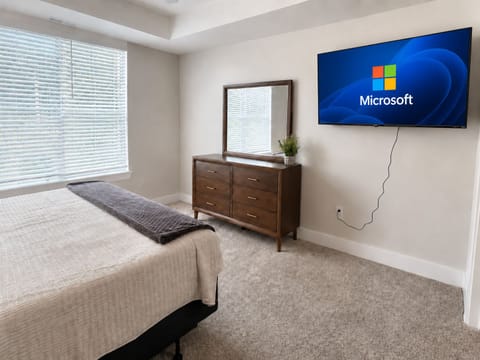 Bedroom with dresser with mirror and TV