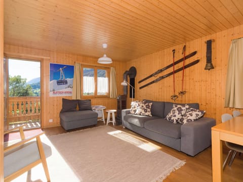 Cozy chalet-style living room with comfortable seating, warm wooden interiors, and mountain views.
