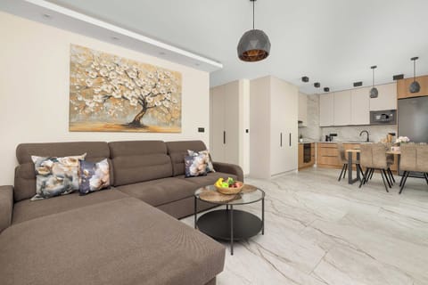A cozy open plan living area with a comfortable sofa and a dining space beside the kitchen. The bright interior creates a welcoming atmosphere for relaxing and spending time together.