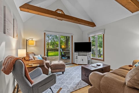 Cozy vaulted living room with deck access and smart TV