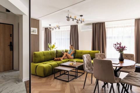 Salon stanowi przestronną i komfortową strefę wypoczynku. Znajduje się w nim duży narożnik, stolik kawowy oraz telewizor Smart TV. W części dziennej przygotowano również stół z miejscami dla sześciu osób.