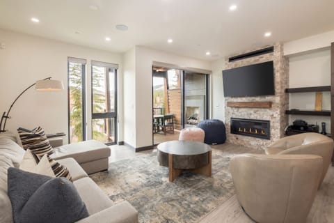 Cozy and bright living room with fireplace, large flat screen tv and patio access