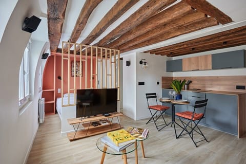 Pièce à vivre avec canapé et cuisine américaine et coin repas