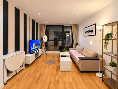 Spacious living room with a TV, comfortable sofa that converts into a bed, and a foldable dining table for flexible dining options.