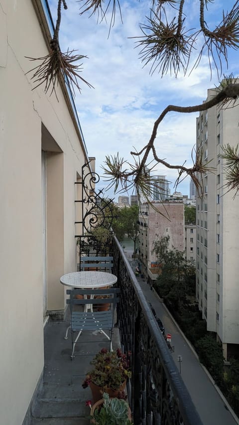 Chambre lumineuse avec lit double et accès direct au balcon, vue dégagée — appartement Paris 19 près du Canal / Bright bedroom with double bed and direct balcony access, open view — apartment in Paris 19 near the Canal