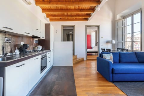 Fully equipped kitchen and living area with exposed wooden beams.