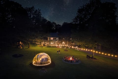 🌌 Starry Skies Sanctuary after dark — the stargazing dome glowing, fire pit lit, and the Milky Way overhead. Every night-sky photo here is real. No AI.