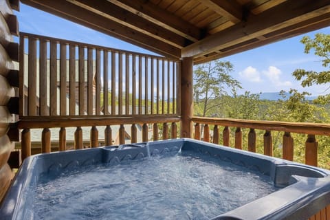 Soak in the private covered hot tub while taking in peaceful wooded views at this Pigeon Forge mountain cabin.